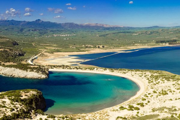 Voidokilia Beach, Messinia: Iconic crescent-shaped beach with turquoise waters, part of a protected natural reserve